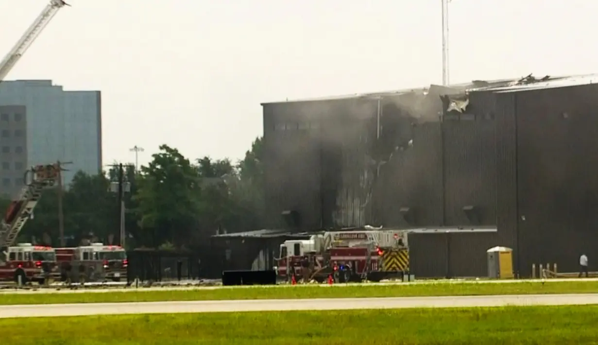 Tim penyelamat berusaha menolong korban saat pesawat bermesin ganda menabrak hanggar di Bandara Addison, Addison, Texas, AS,  Minggu (30/6/2019). Dewan Keselamatan Transportasi Nasional menyatakan telah mengirimkan sebuah tim ke Addison untuk menyelidiki jatuhnya pesawat tersebut. (WFAA-TV via AP)