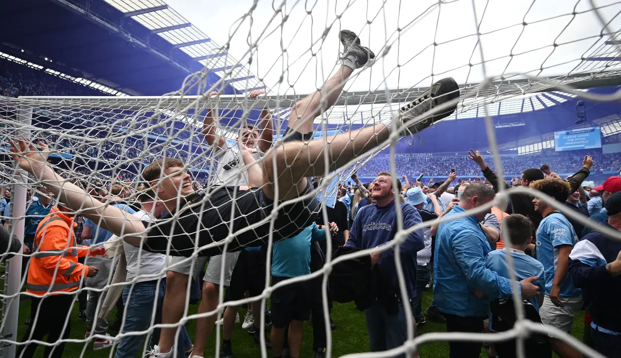 Suporter melakukan selebrasi diatas jaring gawang di Stadion Etihad. (AFP/Oli Scarff)
