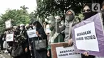 Massa pendukung membawa poster saat sidang perdana Rizieq Shihab di Pengadilan Negeri Jakarta Timur, Jakarta, Selasa (16/3/2021). Massa mendatangi PN Jakarta Timur untuk menyaksikan sidang Rizieq Shihab terkait kasus kerumunan dan tes usap meski digelar secara virtual. (merdeka.com/Iqbal S. Nugroho)