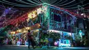 Seorang pria berjalan dengan seekor anjing melewati sebuah rumah bertema Natal di Manila, Filipina (21/12/2022). Perayaan Natal tinggal menghitung hari, warga Manila antusias mengunjungi rumah yang didekor dengan ornamen dan hiasan Natal itu. (AFP/Jam Sta Rosa)