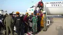 Tentara membantu warga negara Indonesia (WNI) menaiki Boeing 737 TNI AU sebelum dievakuasi dari Port Sudan ke kota Jeddah di Saudi pada 27 April 2023. (Handout/Indonesian Armed Forces (TNI)/AFP)