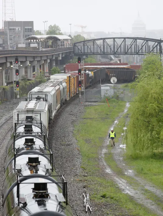 Kondisi kereta barang CSX yang keluar dari rel di bagian timur laut Washington, Minggu (1/5). Menurut keterangan, setidaknya sembilan gerbong kereta anjlok dengan tiga gerbong di antaranya menumpahkan zat kimia berbahaya ke rel. (Andrew BIRAJ /AFP)