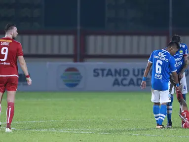 Pemain Persib, Tony Sucipto dan Bojan Malisic menolong pemain Persija yang cedera saat laga lanjutan Go-Jek Liga 1 Indonesia 2018 bersama Bukalapak di Lapangan PTIK, Jakarta, Sabtu (30/6). Laga dimenangkan Persija 1-0. (Liputan6.com/Helmi Fithriansyah)