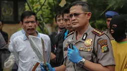 Kapolres Metro Jakarta Utara, Kombes Pol Susetio Cahyadi menunjukan barang bukti senjata tajam saat rilis kasus pembunuhan berencana yang terjadi di Kolong Tol Sedyatmo, di Polsek Metro Penjaringan, Jakarta, Selasa (7/7). (Liputan6.com/Faizal Fanani) 