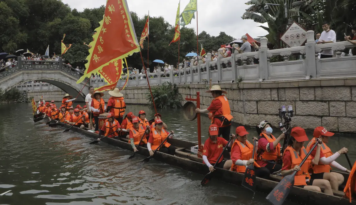 Peserta perahu naga dari desa Panting mendayung di sepanjang kanal di kawasan bersejarah Teluk Lychee di Guangzhou di Provinsi Guangdong, China selatan, Jumat, 3 Juni 2022. Perlombaan perahu naga kembali digelar di beberapa bagian China untuk pertama kalinya sejak merebaknya pandemi pada akhir 2019, saat pembatasan dicabut bersama dengan penurunan besar  kasus COVID-19. (AP Photo/Caroline Chen)