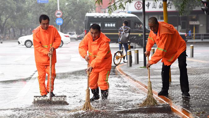 Orang-orang membersihkan genangan air di sebuah jalan di Distrik Haidian, Beijing, ibu kota China (12/8/2020). Badan meteorologi Beijing memperkirakan hujan deras akan mengguyur wilayah Beijing-Tianjin-Hebei antara Rabu (12/8) hingga Kamis (13/8). (Xinhua/Ren Chao)