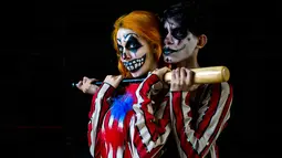 Peserta berpose dengan kostum dan dandanan menyerupai zombie selama acara Zombie Walk di Sao Paulo, Brasil, Sabtu (2/11/2019). Ratusan orang turun ke jalan memakai kostum karakter horor pada acara tahunan yang digelar sejak 2006 pada Hari Para Arwah. (Miguel SCHINCARIOL / AFP)