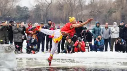 Seorang perenang musim dingin yang mengenakan kostum menyelam ke dalam danau yang sebagian membeku di Shenyang, provinsi Liaoning, China, Selasa (19/2). Mereka percaya berendam di sungai dengan suhu yang ekstrem baik untuk kesehatan. (Photo by STR / AFP)