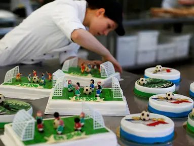 Pembuat kue menyelesaikan tahapan akhir pembuatan beragam kue bertema Euro 2016 yang dibuat di sebuah tempat pembuatan kue di Munich, Jerman, Senin (20/6). Beraneka kue bertema Euro 2016 mewarnai perhelatan sepakbola Eropa. (REUTERS/Michaela Rehle)