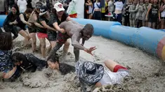 Sejumlah turis mengikuti sebuah permainan dalam Festival lumpur Boryeong di pantai Daecheon, Boryeong, Korea Selatan, (15/7). Festival lumpur Boryeong selalu mengadakan berbagai perlombaan yang menggunakan arena berlumpur. ( REUTERS/Kim Hong-Ji)