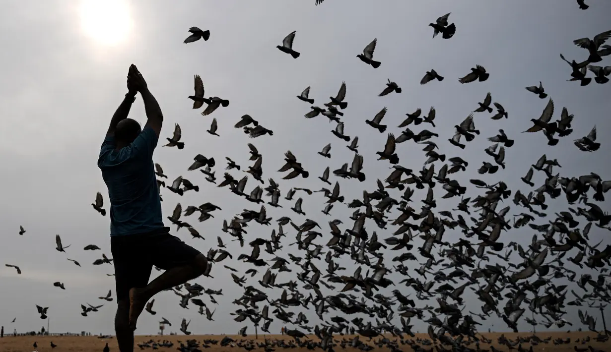 Di berbagai wilayah di India, peringatan Hari Yoga Internasional diisi dengan sesi yoga massal, baik itu di taman-taman, pusat kebugaran, bahkan tempat kerja. (R. Satish BABU/AFP)
