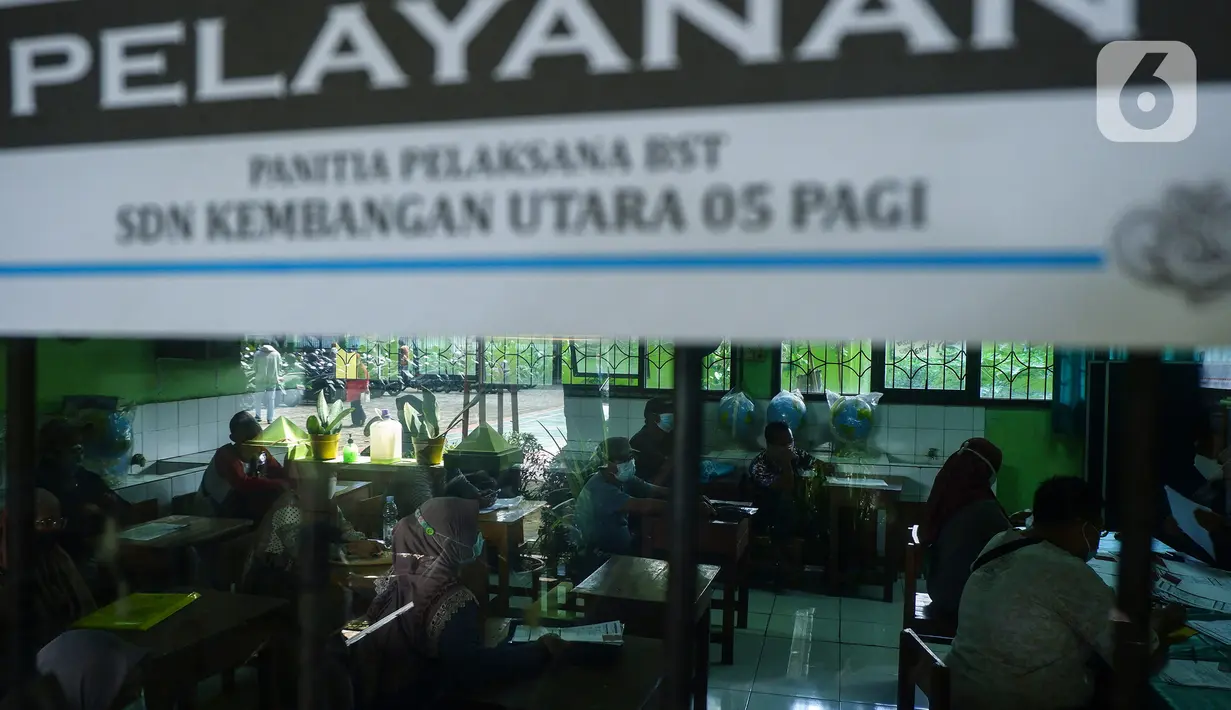 Suasana pencairan bantuan sosial tunai (BST) terhadap warga penerima manfaat di SDN Kembangan Utara 05 Pagi, Jakarta, Rabu (31/3/2021). Program BST sebesar Rp300 ribu dari Kemensos ini disalurkan melalui RT-RT se kelurahan Kembangan Utara melalui ATM Bank DKI. (Liputan6.com/Johan Tallo)
