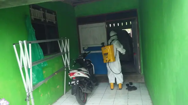 Petugas dari Satgas Penanganan Covid-19 Purbalingga menyemprot cairan disinfektan di rumah warga Desa Karanggambas Kecamatan Padamara, Kabupaten Purbalingga, Minggu (22/11/2020). (Foto: Liputan6.com/Rudal Afgani Dirgantara)