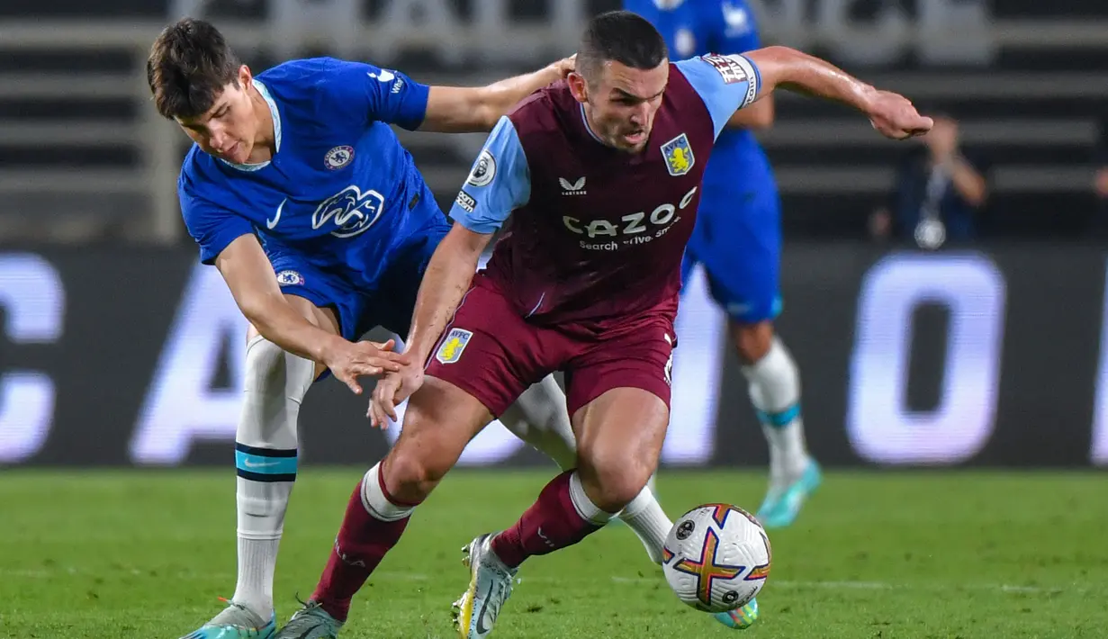 <p>Gelandang Chelsea Cesare Casadei (kiri) berebut bola dengan gelandang Aston Villa, John McGinn (kanan) selama pertandingan uji coba di Stadion al-Nahyan di Abu Dhabi (11/12/2022). Aston Villa menang tipis atas Chelsea dengan skor 1-0. (AFP/Ryan Lim)</p>