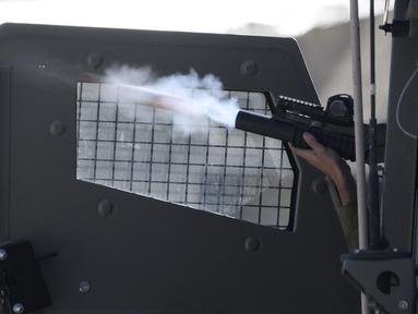 Seorang tentara Israel menembakkan proyektil selama bentrokan di kota Nablus di Tepi Barat yang diduduki pada 3 April 2023, menyusul serangan oleh pasukan Israel. (AFP/Jaafar Ashtiyeh)