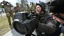 Anggota Pasukan Pertahanan Teritorial Ukraina memeriksa persenjataan baru, termasuk sistem anti-tank NLAW dan peluncur granat anti-tank portabel lainnya, di tengah invasi Rusia yang sedang berlangsung ke Ukraina di Kiev (9/3/2022). (AFP/Genya Savilov)