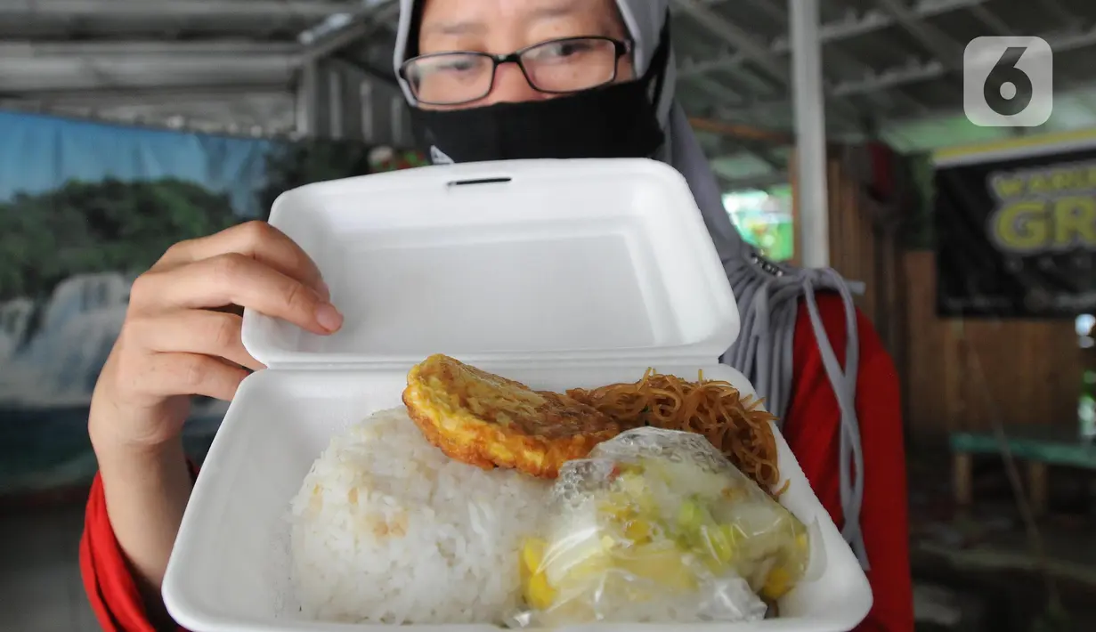 Warga menunjukkan makan siang gratis di Warung Makan Gratis Beji, Depok, Jawa Barat, Rabu (9/3/2022). Relawan menyediakan 100 porsi makanan sebagai bentuk kepedulian terhadap masyarakat yang ekonominya terdampak pandemi  COVID-19. (merdeka.com/Arie Basuki)