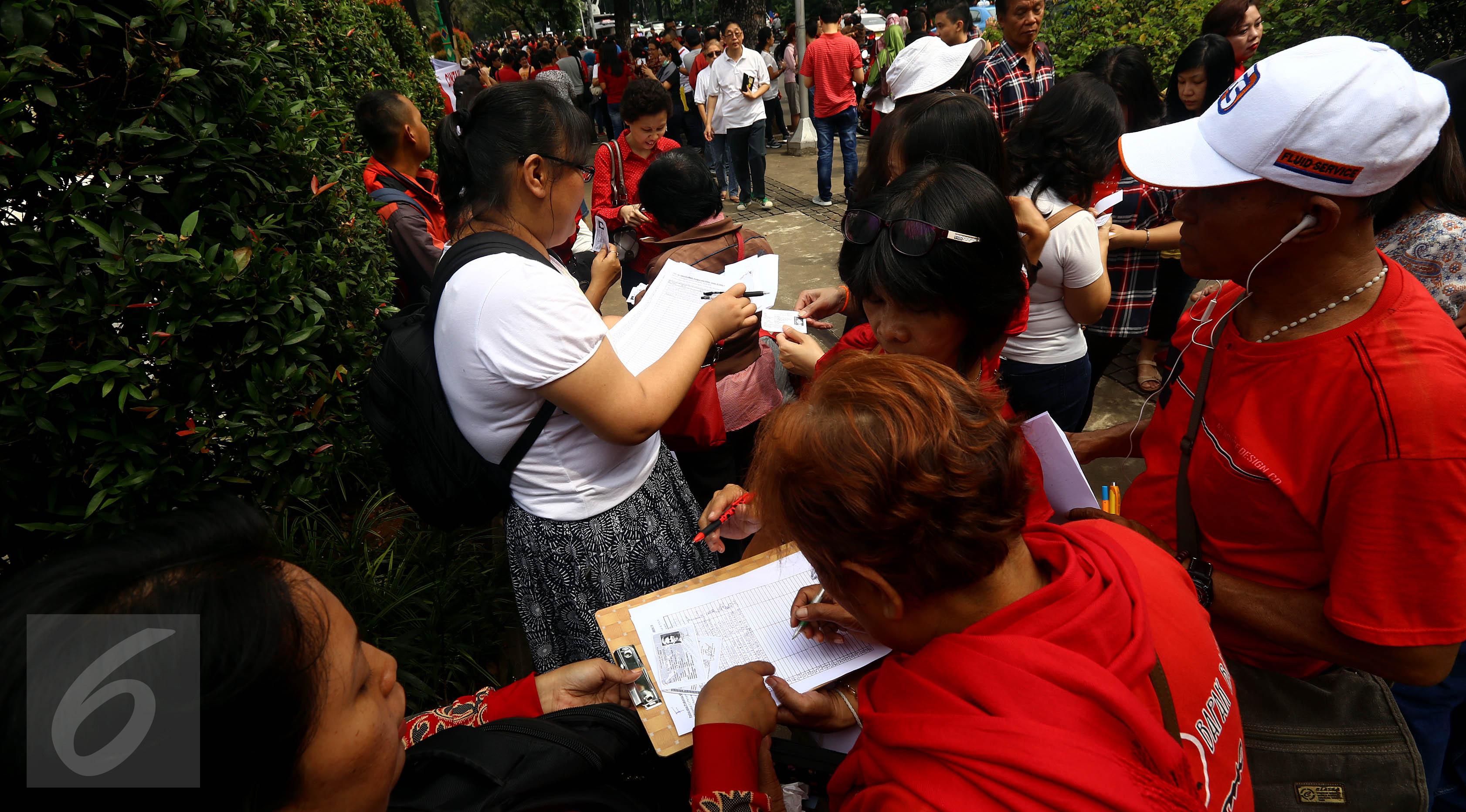 Sejumlah warga mengisi formulir pendataan dan pengumpulanKTP di depan Balai Kota, Jakarta, Kamis (5/11). Pendataan dan pengumpulan KTP tersebut sebagai petisi penangguhan penahanan Ahok sebagai Tahanan Kota. (Liputan6.com/Johan Tallo)