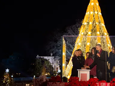 Presiden AS Barack Obama (kedua kanan) didampingi Michele Obama, dan dua putrinya menyalakan Pohon Natal Nasional di Taman Ellipse, dekat Gedung Putih, Washington, Kamis (3/12). Acara tersebut menandai dimulainya musim Natal. (AFP PHOTO/JIM WATSON)