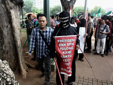 Aksi jalan kaki sambil menutup mata di depan Istana Negara, Jakarta, Selasa (18/11/2014). (Liputan6.com/Faizal Fanani)