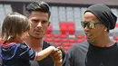 Eks Striker Barcelona, Ronaldinho menyapa gadis kecil sebelum pertandingan persahabatan melawan mantan pemain Kosta Rika di Stadion Nasional di San Jose, (4/8). (AFP Photo/Ezequiel Becerra)