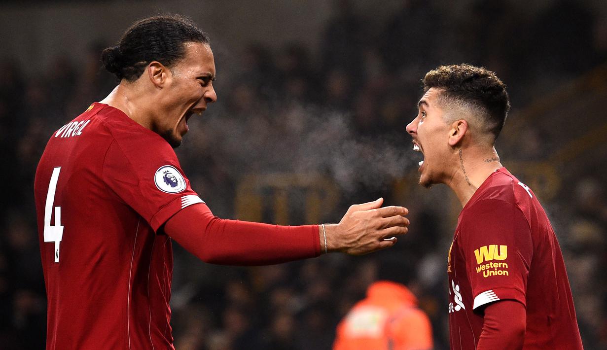 Pemain Liverpool Roberto Firmino (kanan) merayakan golnya ke gawang Wolverhampton Wanderers bersama Virgil van Dijk pada pertandingan Liga Inggris di Molineux Stadium, Wolverhampton, Inggris, Kamis (23/1/2020). Liverpool menang 2-1. (Oli SCARFF/AFP)
