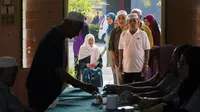 Warga Malaysia mengantre di tempat pemungutan suara untuk memilih perdana menteri di Alor Setar, Rabu (9/5). Pemerintah menetapkan hari ini sebagai hari libur agar warganya bisa memenuhi tanggung jawab mereka sebagai pemilih. (Jewel SAMAD / AFP)