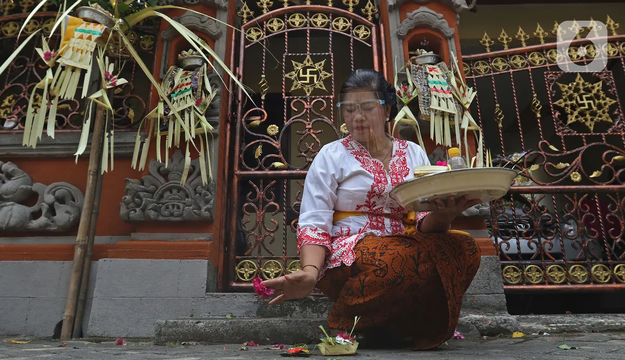 Umat Hindu saat melaksanakan ritual persembahyangan Hari Raya Galungan di Kampung Bali, Bekasi Utara, Jawa Barat, Bekasi, Rabu (16/9/2020). Perayaan hari kemenangan kebenaran (Dharma) atas kejahatan (Adharma) tersebut dilakukan di kediaman masing-masing. (Liputan6.com/Herman Zakharia)