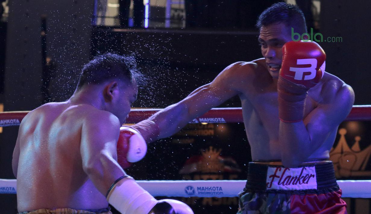 Ilham Leoisa (kanan) membongkar pertahanan petinju Thailand, Paiboon Lorkham pada laga kelas Super-Lightweight Mahkota Boxing Super Series di Cilandak Town Square, Jakarta (10/3/2018). Ilham menang angka mutlak. (Bola.com/Nick Hanoatubun)