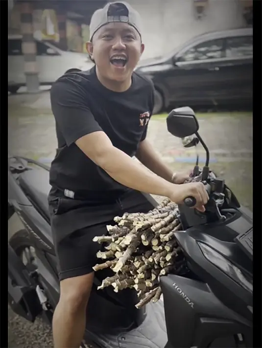 Kalau artis lain banyak yang pamer kemewahan, tapi Denny Caknan terlihat santai hidup sederhana.Momen naik motor bebek metik membawa potongan pohon singkong untuk ditanam. [Instagram/denny_caknan]