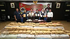 Petugas menunjukkan barang bukti dan tersangka saat rilis pengungkapan jaringan Narkotika sindikat Aceh-Jakarta-Bali di Jakarta, Senin (28/12/2015). Bareskrim amankan 3 kg sabu, 14.000 butir ekstasi, dan 1,5 ton ganja. (Liputan6.com/Immanuel Antonius) 