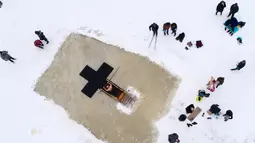 Penganut Kristen Ortodoks Rusia berkumpul untuk berenang di air es saat Epiphany di Desa Orlino, selatan Saint Petersburg, Jumat (19/1). Ribuan penganut Kristen Ortodoks akan terjun ke sungai dan kolam es di seluruh negeri. (AP Photo/Dmitri Lovetsky)