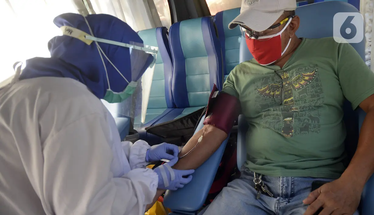 Petugas Palang Merah Indonesia (PMI) mengambil darah pendonor di mobil donor darah keliling, Tangerang Selatan, Banten, Jumat (17/7/2020). PMI mengintensifkan pengoperasian mobil donor darah keliling untuk memenuhi persediaan stok darah saat pandemi COVID-19. (merdeka.com/Dwi Narwoko)