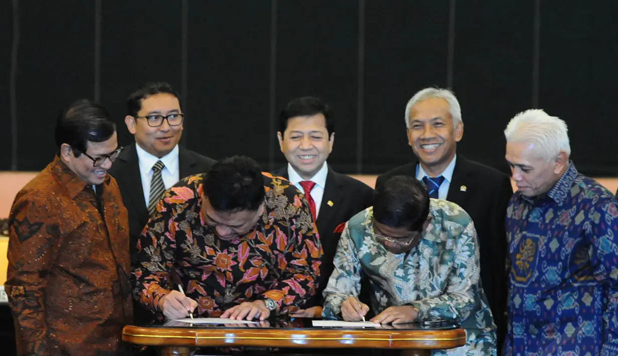 KIH diwakili Olly Dondokambey dan KMP diwakili Sekjen Partai Golkar Idrus Marham (kanan) saat menandatangi kesepakatan damai di Gedung DPR RI, Jakarta, Senin (17/11/2014). (Liputan6.com/Andrian M Tunay)