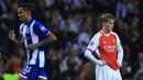Ekspresi kecewa pemain Arsenal, Martin Odegaard (kanan) setelah timnya dibobol oleh pemain Porto Wanderson Galeno (kiri) pada laga leg pertama 16 besar Liga Champions 2023/2024 di Dragao stadium, Porto, Portugal, Kamis (22/02/2024) dini hari WIB. (AFP/Patricia De Melo Moreira)