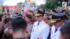 Sebelum masuk ke Balai Kota, Anies Sandiaga disambut masyarakat yang menunggu di luar gedung, lengkap dengan parade tarian dan kesenian.
