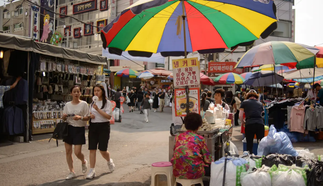 Dua wanita berjalan di antara kios di pasar Namdaemun di Seoul (2/7/2019). Pasar Namdaemun atau Namdaemun Sijang adalah pasar yang terletak di Seoul, Korea Selatan. Pasar ini terletak di sebelah timur Gerbang Besar Selatan (Sungnyemun) yang bersejarah dengan luas 40.000 m². (AFP Photo/Minji Suh)