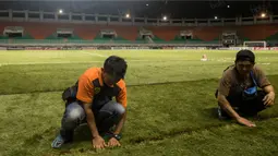 Pekerja merapihkan rumbut sintetis saat persiapan jelang laga semifinal Piala AFF 2016 antara Timnas Indonesia melawan Vietnam di Stadion Pakansari, Jawa Barat, Jumat (3/12/2016). (Bola.com/Vitalis Yogi Trisna)