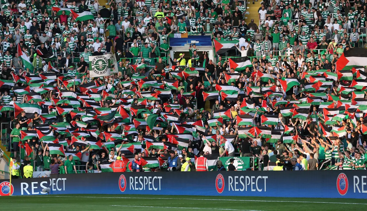Para suporter Celtic mengibarkan bendera Palestina saat melawan Hapoel Beer Sheva asal Israel di babak kualifikasi play off Liga Champions di Celtic park, (19/8).  Aksi ini juga untuk mendukung kemerdakaan Palestina. (REUTERS/Russell Cheyne)