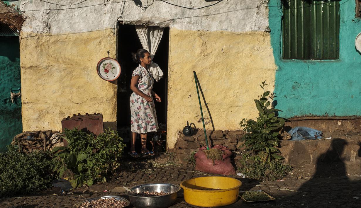 Seorang perempuan berdiri di depan pintu sebuah rumah di Kota Gondar, Ethiopia pada 09 November 2020. (Photo by EDUARDO SOTERAS / AFP)