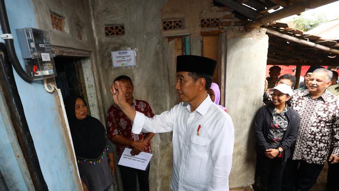 Presiden Joko Widodo saat meninjau rumah yang telah dipasang listrik gratis di Kampung Pasar Kolot, Garut, Jawa Barat, Jumat (18/1). Pemasangan listrik gratis diberikan kepada keluarga prasejahtera. (Liputan6.com/Angga Yuniar)