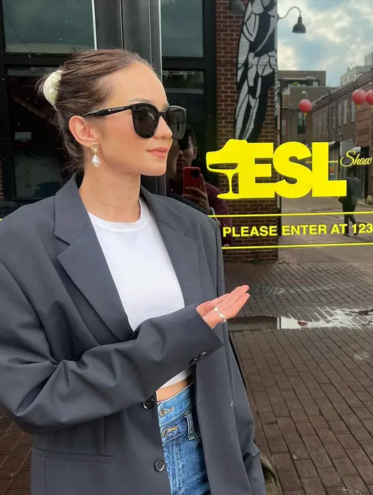 Tampil bak warga lokal, Enzy Storia menawan dengan pilihan outfitnya. Cropped top putih polos, ditumpuknya dengan oversized blazer, dan dipadu dengan celana jeans, Enzy menambahkan sentuhan sunglasses yang membuat penampilannya semakin slay. [Foto: Instagram/enzystoria]