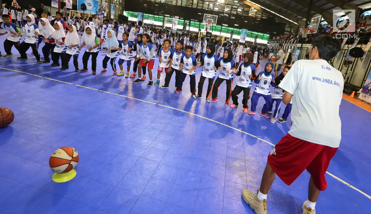 Pelatih memberikan pemanasan kepada anak-anak pada program Junior NBA Indonesia di Cilandak, Jakarta, Sabtu (24/3). Kegiatan yang didukung Frisian Flag diharapkan mampu menjangkau lebih dari 12.000 anak-anak. (Liputan6.com/Fery Pradolo)
