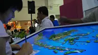 Seorang pengunjung pameran wisata MITM sedang mencari destinasi wisata Indonesia menggunakan peta interaktif. 