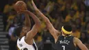 Aksi pemain San Antonio Spurs, Rudy Gay (kiri) melepaskan tembakan melewati adangan pemain Golden State Warriors, JaVale McGee pada playoffs NBA Basketball di Oracle Arena, Oakland, California, (16/4/2018). Warriors menang 116-101. (AP/Ben Margot)