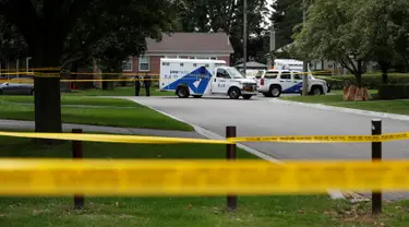 Petugas kepolisian berdiri di lokasi penyerangan dengan busur panah di kawasan Scarborough, Toronto, Kanada, Kamis (25/8). Insiden penyerangan tersebut mengakibatkan tiga orang tewas karena luka yang dipicu oleh anak panah. (REUTERS/Mark Blinch)