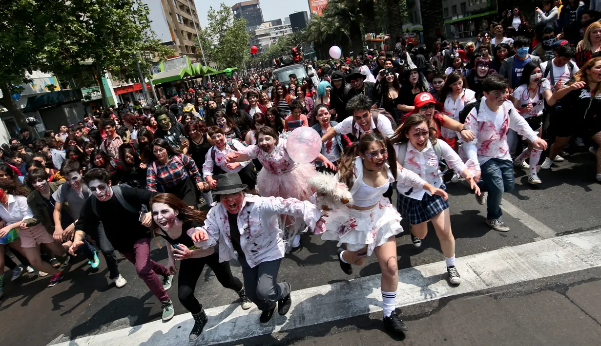 Ratusan orang berkostum menyerupai zombie berpartisipasi dalam perayaan satu dekade Zombie Walk di Santiago, Chile, 13 Oktober 2018. Zombie Walk merupakan acara tahunan yang terinspirasi dari acara televisi AS 'The Walking Dead'. (AP/Esteban Felix)