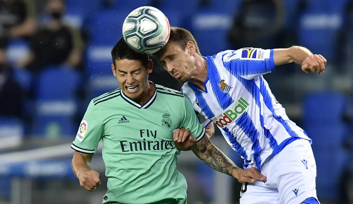 Pemain Real Madrid, James Rodriguez, duel udara dengan pemain Real Sociedad, Nacho Monreal, pada laga La Liga di Reale Seguros Stadium, Minggu (21/6/2020). Real Madrid menang 2-1 atas Real Sociedad. (AP Photo/Alvaro Barrientos)