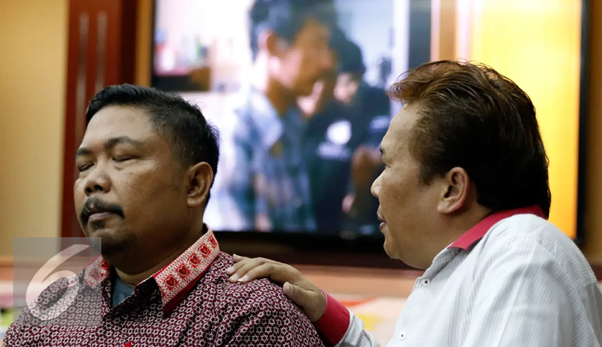 Seorang kerabat keluarga menenangkan suami korban saat rilis pengungkapan kasus pembunuhan di Cakung, Jakarta, Jumat (16/10/2015). Motif Pembunuhan Ibu dan Anak di Cakung Murni Perampokan. (Liputan6.com/Yoppy Renato)