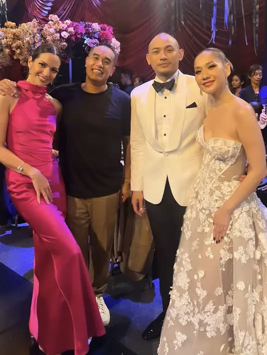 Nia Ramadhani hadir mengenakan long dress fuchsia halter neck, sementara sang suami mengenakan setelan jas coklat dengan inner kaos hitamnya. [@ramadhaniabakrie]